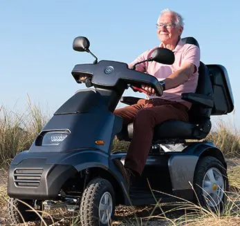Person driving the Afiscooter S4 mobility scooter on rough terrain
