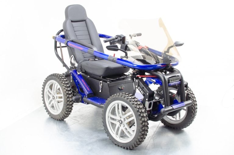 Seated four wheel drive off road wheelchair with knobby tires photographed outdoors from the front