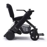 Black Whill Model F power wheelchair featuring sturdy wheels, a comfortable seat, and an under-seat mesh basket for storage.