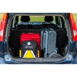 The eFOLDi Explorer scooter neatly packed in the trunk of a car, demonstrating the ease with which it can be transported alongside other luggage.