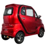 Three Quarter View of Glossy red Green Transporter Q Express, with a curvy design and chrome accents, offers a stylish, eco-friendly travel option for city dwellers.
