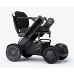 A sleek, black power wheelchair enhanced with advanced maneuverability, featuring robust, textured wheels and a contoured seat for maximum comfort and mobility support.