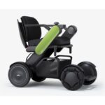 A vibrant power wheelchair with a green armrest, combining cutting-edge functionality with an eye-catching design, equipped with rugged wheels for superior traction and a plush seat for comfort.