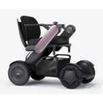 An elegant pink color power wheelchair featuring a comfortable high-back seat, precision control joystick, and durable wheels for smooth, stylish mobility assistance.