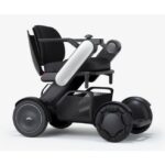 A contemporary black power wheelchair, featuring a sleek white armrest for a modern look, complemented by durable wheels and comfortable seating for enhanced daily mobility.