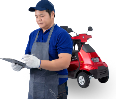 A person wearing a blue cap, blue shirt, and apron stands while writing on a clipboard. Behind them, there is a red three-wheeled vehicle. The individual appears to be performing a maintenance or inspection task.