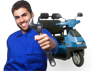 A smiling man in a blue jumpsuit holds a large wrench towards the camera. Behind him is a blue mobility scooter.