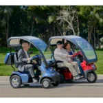 Live Style Image Side View of Blue Afiscooter S4 with Canopy Mobility Scooter, Red Afiscooter S3 Dual Seat Mobility Scooter with Canopy Golf Tires