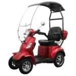 Daymak Roadstar in red with a canopy and windshield, featuring a black cushioned seat, rear storage compartment, and chrome wheels.