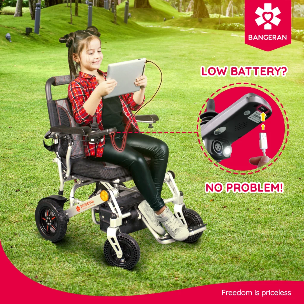 Child sitting on Bangeran Pegasus foldable electric wheelchair charging tablet through USB port outdoors