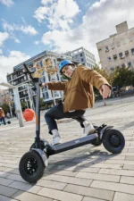 Person riding MIA SPYQE 2x4 electric scooter on city street showing powerful dual motor performance and stable ride explore the SPYQE electric scooter today