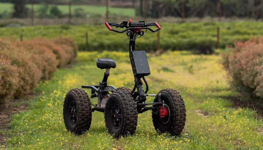 EZRaider HD4 4x4 off-road electric scooter with seat parked on grassy trail surrounded by green and brown bushes