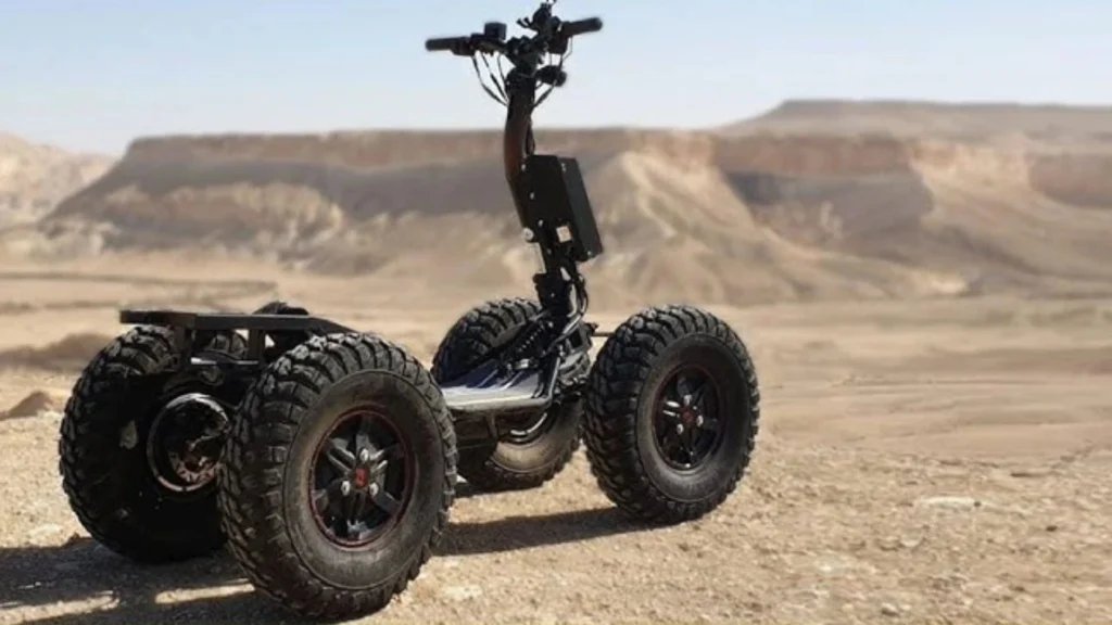EZRaider HD4 4x4 off-road electric scooter with rugged tires parked on sandy desert terrain with rocky hills in the background