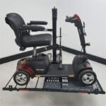 Side view of a 4 wheel scooter held by the US218 automatic hold down arm