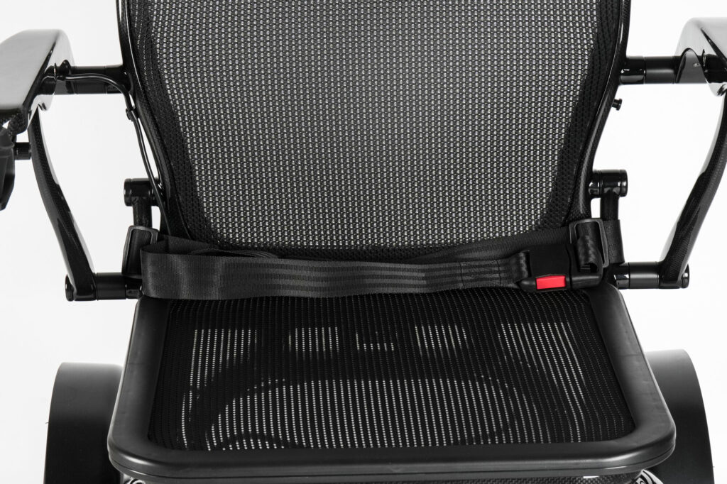 Porto Mobility Ranger TorqueLite folding power wheelchair, seat belt across the mesh seat close up